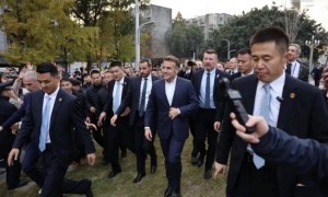 巩俐陪马克龙夫妇吃烤鸭，穿黑衣扎丸子头气场强，快六十岁还很美